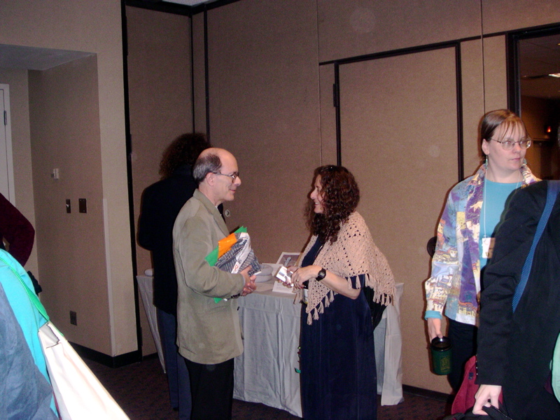 someone I don't know confers with Susan Schwartz Wildstrom at the exhibit, with someone I should know but at the moment don't wears a cool jacket on the right.